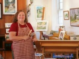 Lady artist standing near artwork