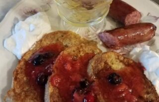 Breakfast of toast with jam, sausage and fruit