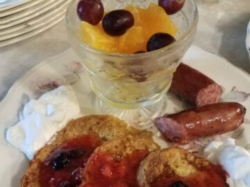 Breakfast of toast with jam, sausage and fruit