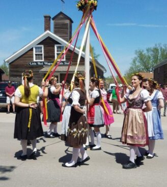 Ladies in period costume around maypole at Maifest