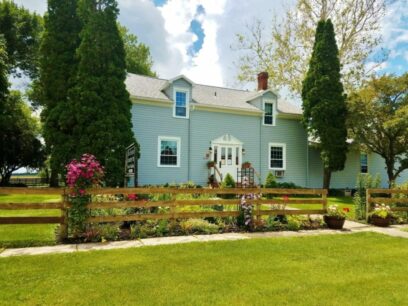 Front view of inn with clematis blooming along the fence