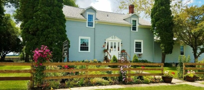 Front view of inn with clematis blooming along the fence