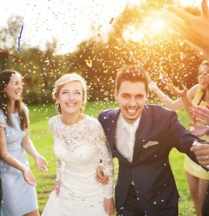 bride and groom running through guests throwing confettii