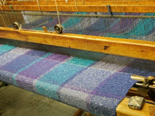 closeup of loom weaving fabric