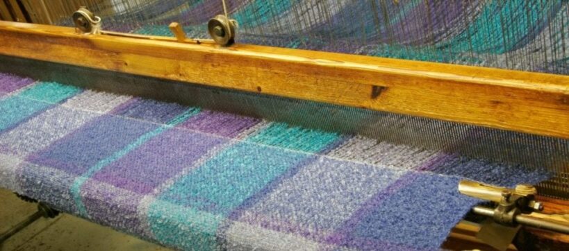 closeup of loom weaving fabric